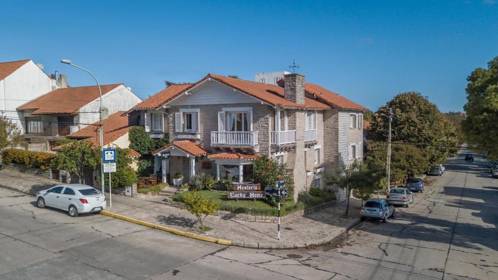 une maison dans une rue avec des voitures garées devant dans l'établissement Hosteria Lucky Home, à Mar del Plata