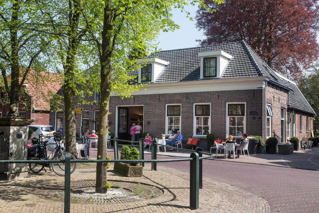 een groep mensen die buiten een gebouw zitten bij Herberg Swaen aan de Brink in Den Ham