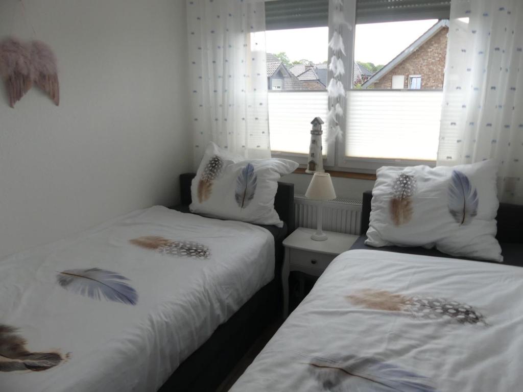sypialnia z 2 łóżkami z białą pościelą i oknem w obiekcie Ferienwohnung Anke - Apartment 5d w mieście Heinsberg