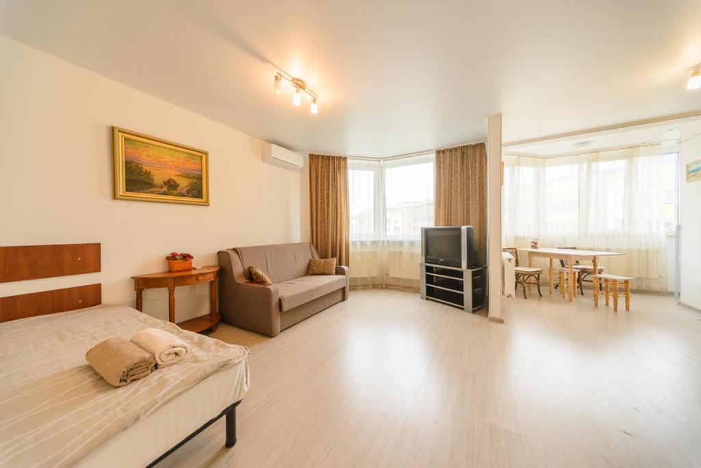 キーウにあるBright new apartment near airport Zhylaynyのベッドルーム1室(ベッド1台、ソファ、テーブル付)