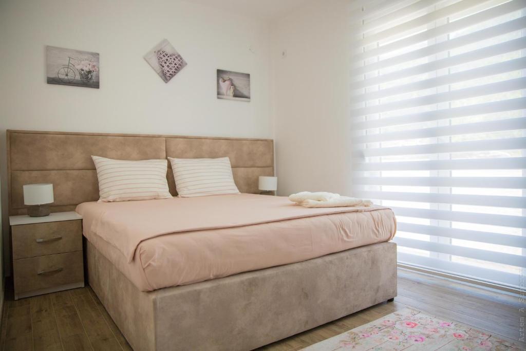 a bedroom with a large bed with a large window at Apartments Sunny Hill in Tivat