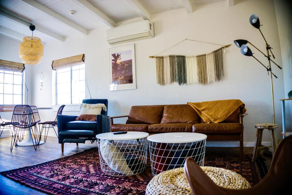 sala de estar con sofá y mesa en M&L Desert Cottage - 6 min To North Entry Of JTNP!, en Twentynine Palms