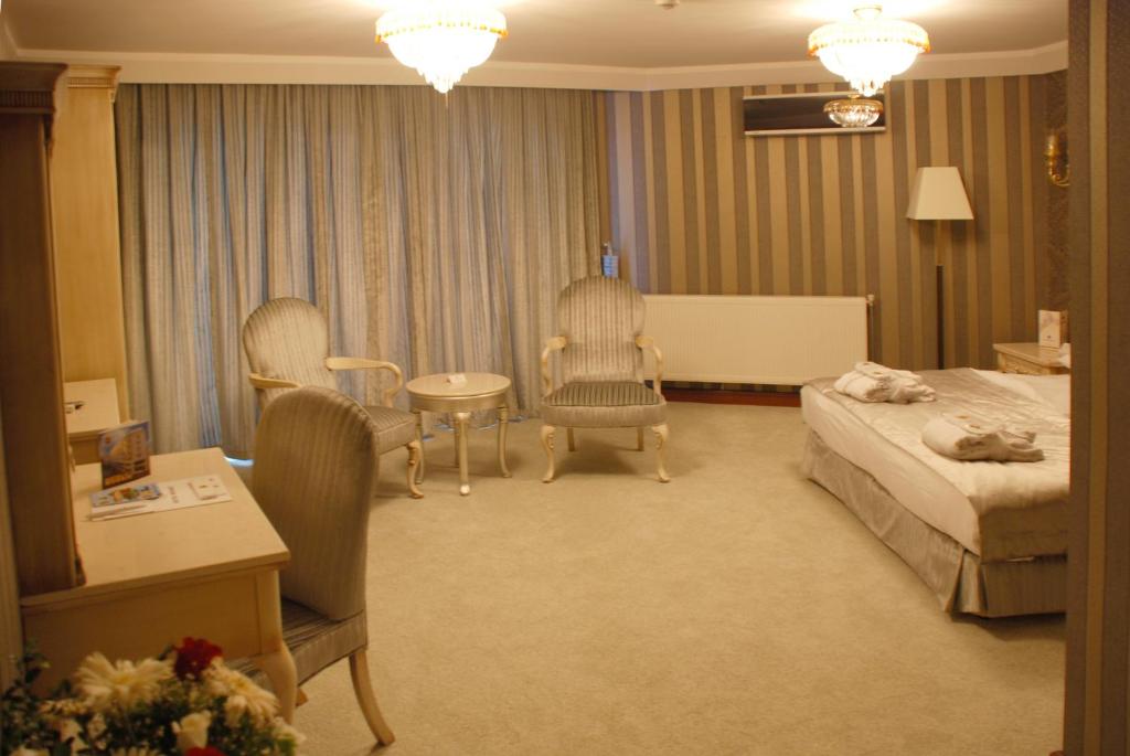 a hotel room with a bed and a table and chairs at Mosaic Hotel Old City -Special Category in Istanbul
