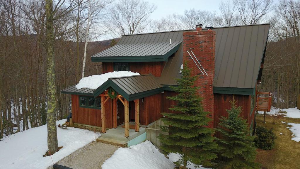 ein kleines rotes Haus mit Schnee darauf in der Unterkunft Cedarwalk in Killington