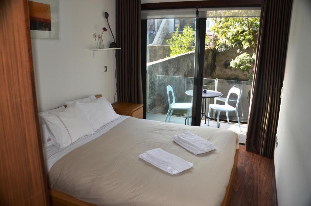 een slaapkamer met een bed met twee handdoeken erop bij PATH Dukes Apartment in Porto