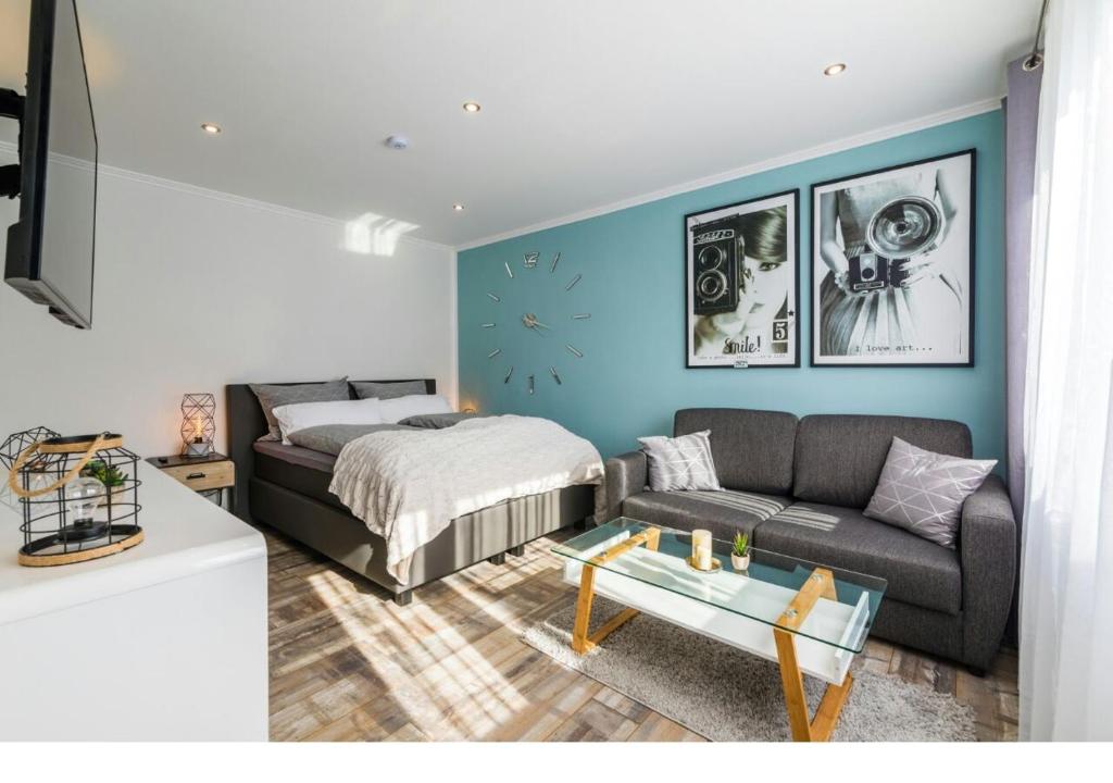 ein Wohnzimmer mit einem Sofa und einem Bett in der Unterkunft Gepflegte und moderne Ferienwohnung in der Neuseenlandschaft in Neukieritzsch
