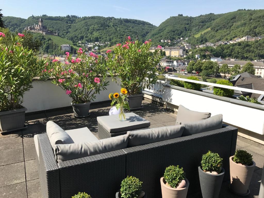 a balcony with couches and potted plants and flowers at Ferienwohnung Berens in Cochem
