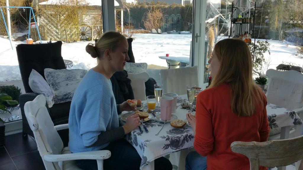 two women sitting at a table eating food at Villa Jani b&amp;b in Breitscheid