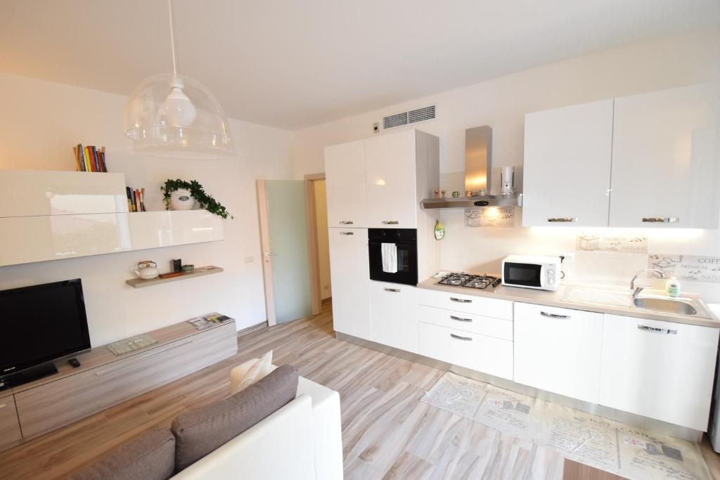 una cocina con armarios blancos y un sofá en una habitación en Uptoyou, en Milán