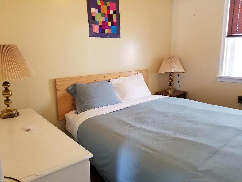 a bedroom with a large bed and two lamps at Melsask Motel in Melville