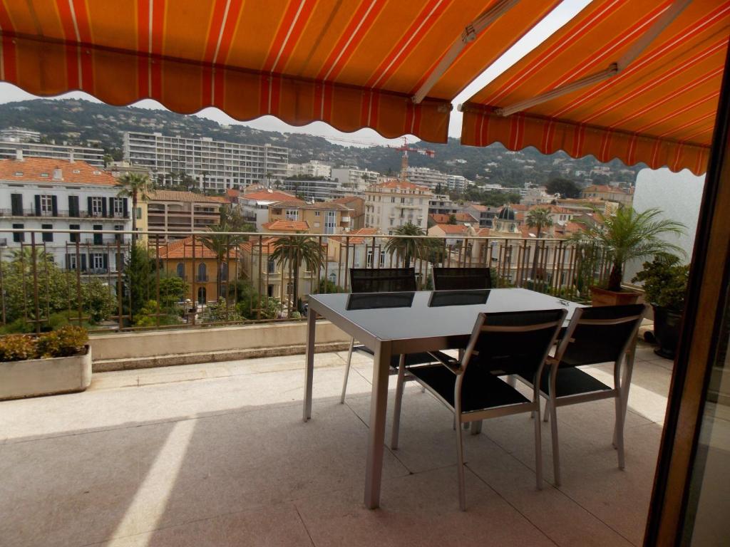 une table et des chaises sur un balcon avec vue dans l'établissement Cannes Satellite, à Cannes