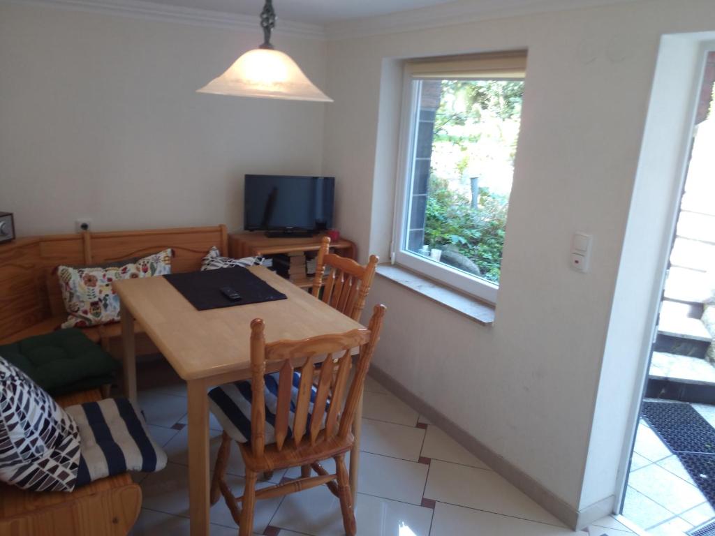 a dining room with a table and chairs and a window at Teltow Ferienwohnung in Teltow