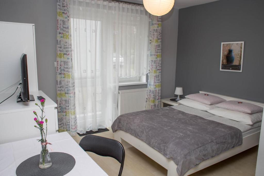 Un dormitorio con una cama y una mesa con un jarrón. en Pokoje gościnne Grafit, en Władysławowo