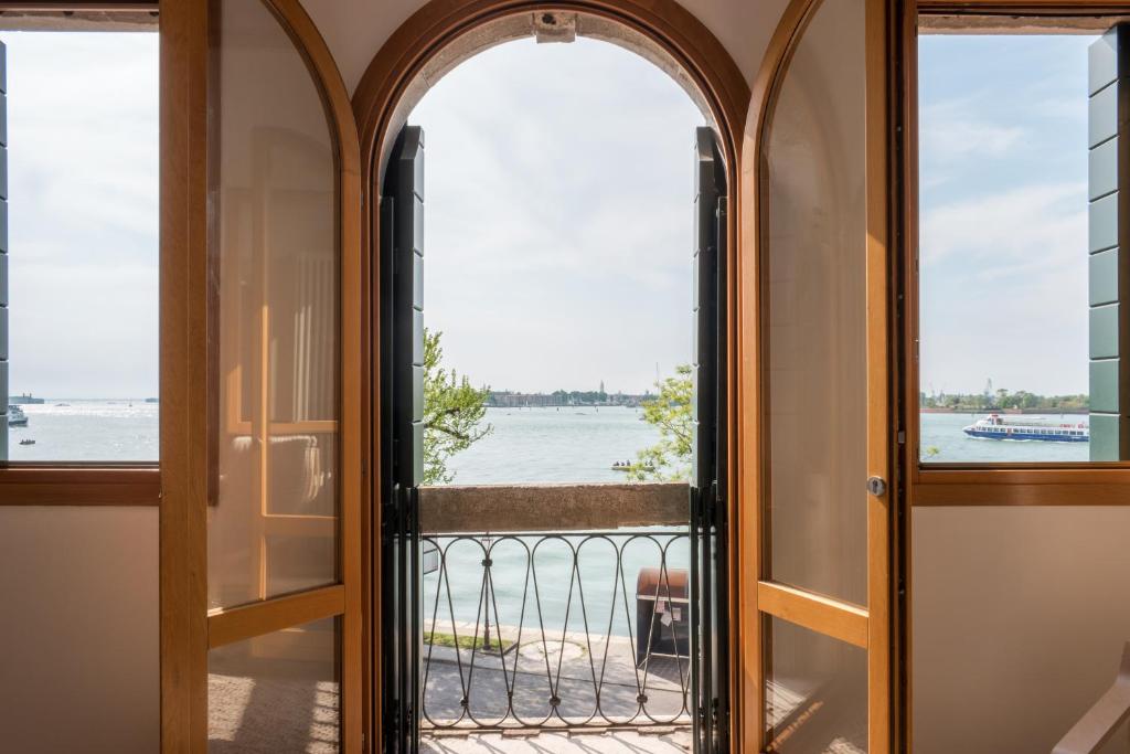 an open door to a balcony with a view of the water at Cà Nicoletto by Venicevillas, Lido in Venice-Lido