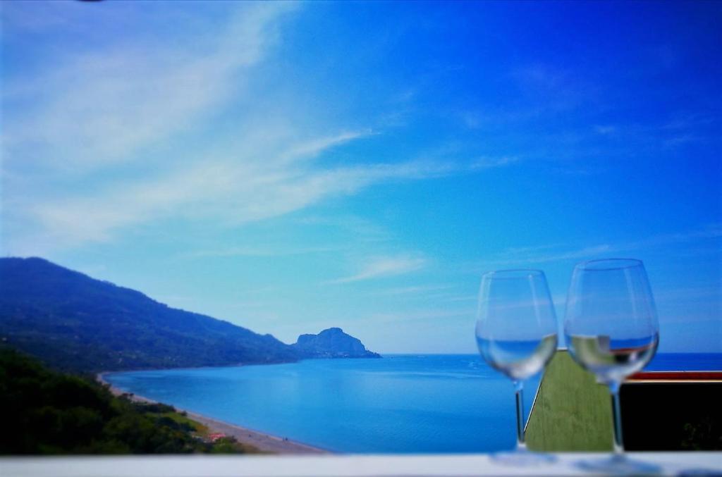 チェファルにあるSweet House Salvinaの海辺のテーブルに座るグラス2杯