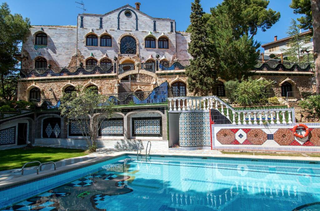 a house with a swimming pool in front of a building at Apartamentos Gaudi Style in Náquera