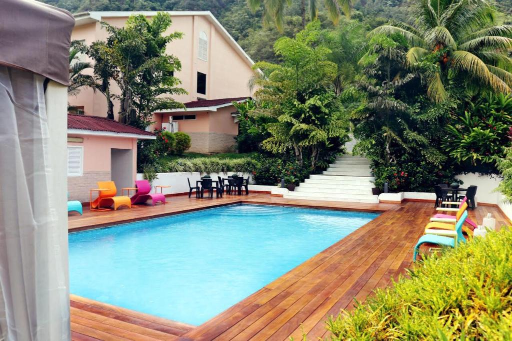 una piscina con terraza de madera y una casa en Hotel Presidente Selva, en La Merced