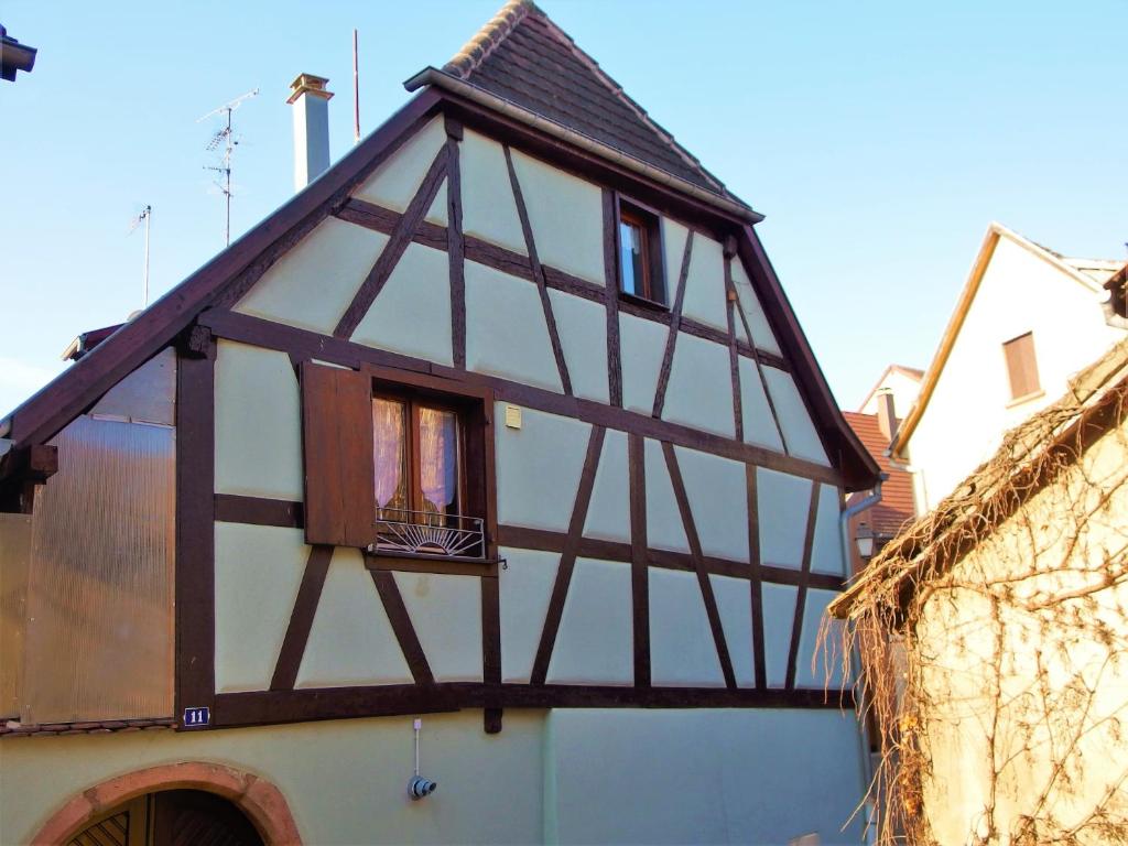 uma casa com uma janela do lado de um edifício em La maison Céline em Bergheim