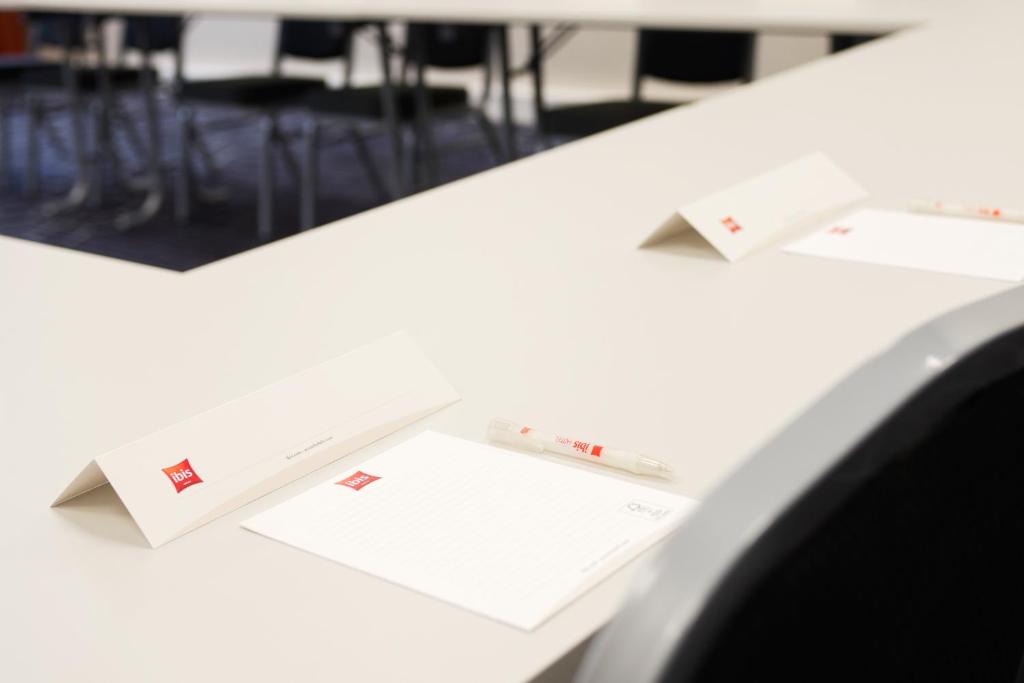 a white desk with two papers on top of it at ibis Rotterdam Vlaardingen in Vlaardingen