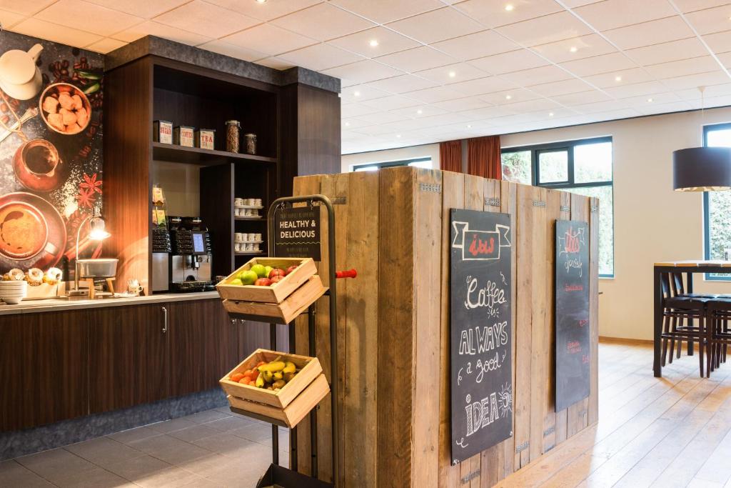 a restaurant with a refrigerator with baskets of fruit on it at ibis Rotterdam Vlaardingen in Vlaardingen