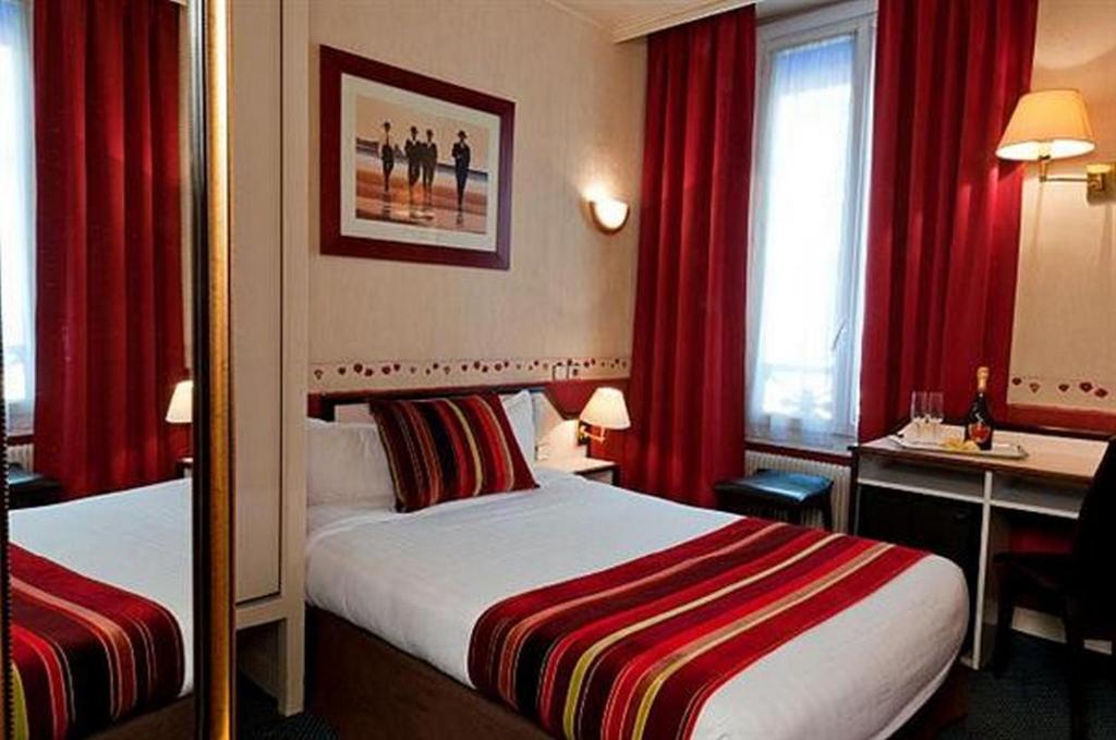 a hotel room with a bed and red curtains at Opera Deauville in Paris