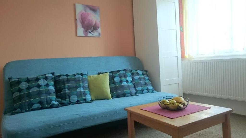 ein blaues Sofa im Wohnzimmer mit einem Tisch in der Unterkunft Apartment Provence in Franzensbad