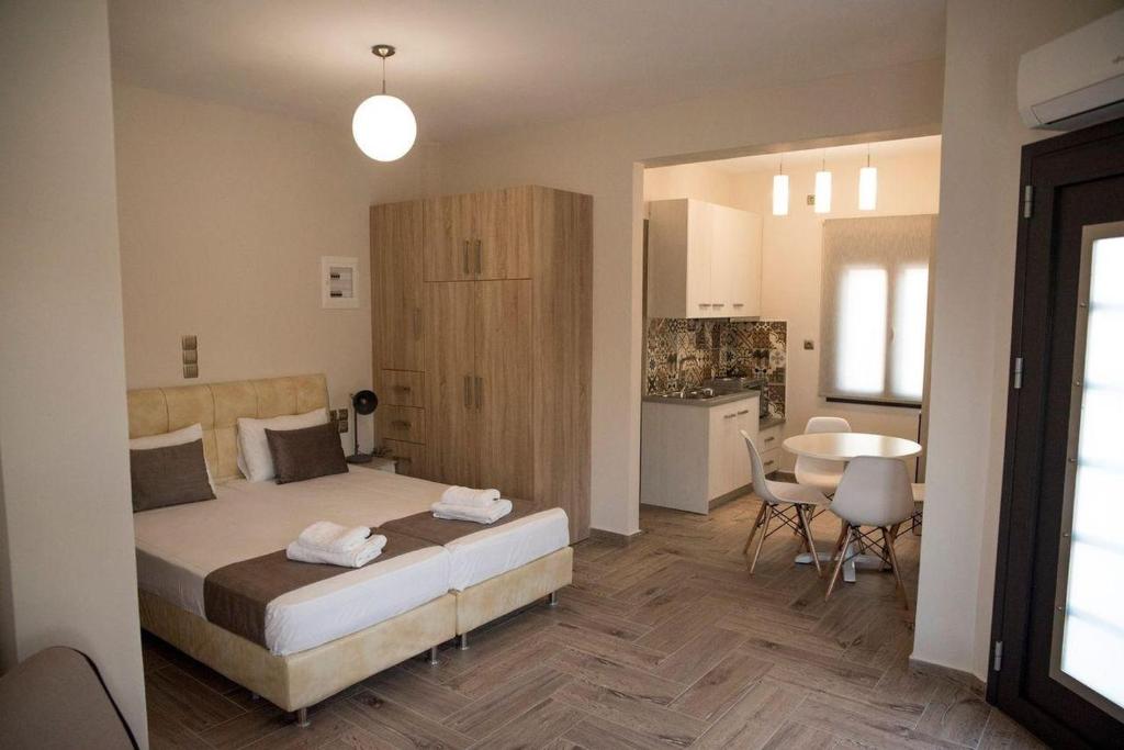 a bedroom with a bed and a table and a kitchen at Mais Studios in Vatera