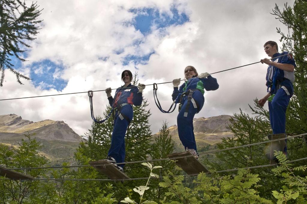 a group of people on a zip line in the mountains at Rock Noir & Spa in La Salle-les-Alpes