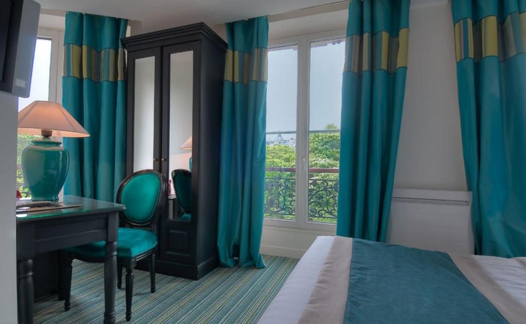 a hotel room with a bed and a desk and a window at Hotel Cluny Square in Paris