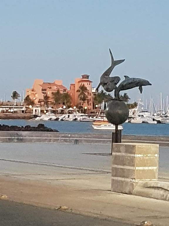 Una statua di un uccello che vola sopra un corpo d'acqua. di Hotel Calafia a La Paz