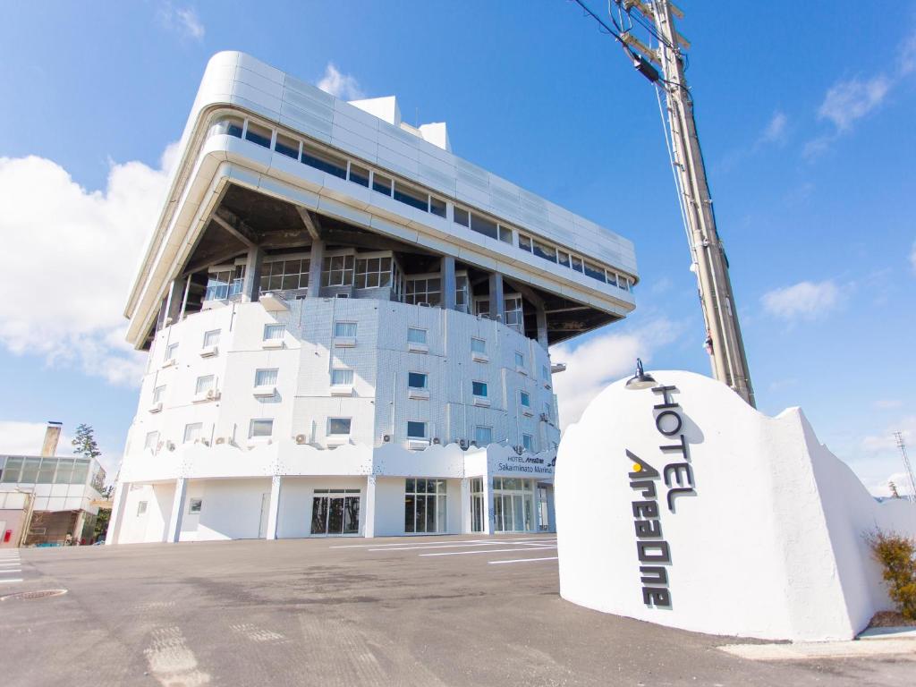 un gran edificio blanco con un cartel delante en Hotel AreaOne Sakaiminato Marina en Sakaiminato