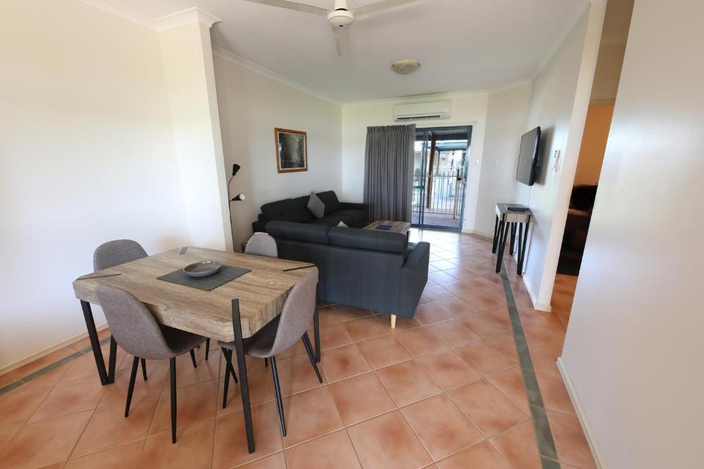 - un salon avec une table et un canapé dans l'établissement Lakeview Apartments, à Kununurra