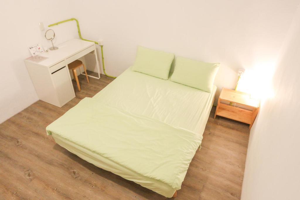 a small bedroom with a bed and a desk at T-Life Hostel in Longjing