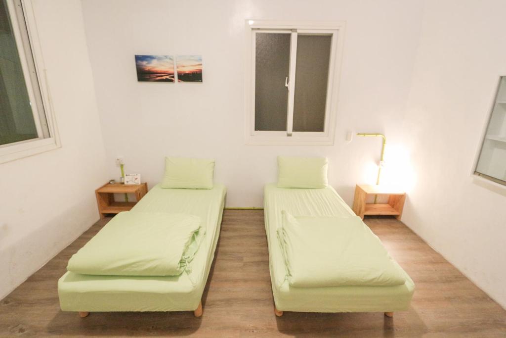 a room with two beds and a window at T-Life Hostel in Longjing