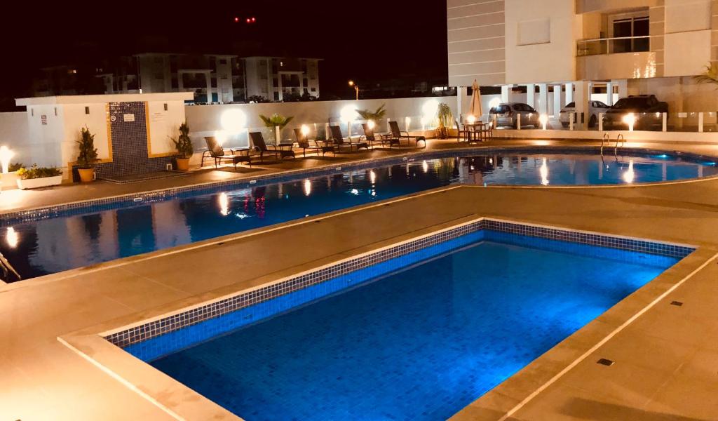 a large swimming pool in a hotel at night at Apartamento completo na Paradisíaca Praia dos Ingleses in Florianópolis