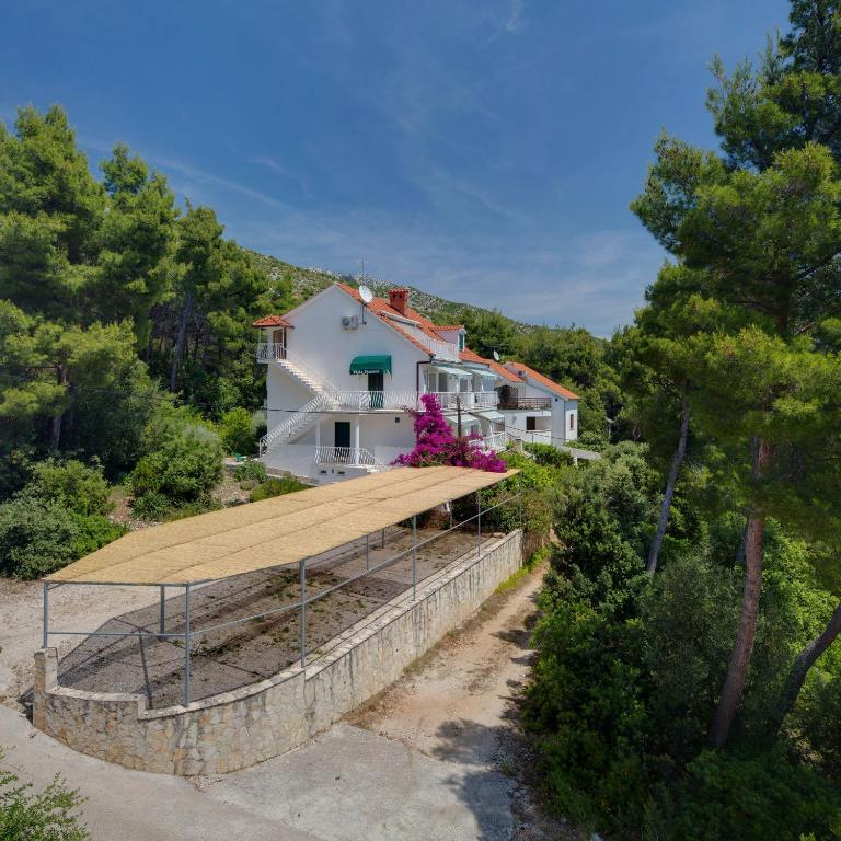 a house with a large wooden roof on a hill at Villa Tamara in Zavala