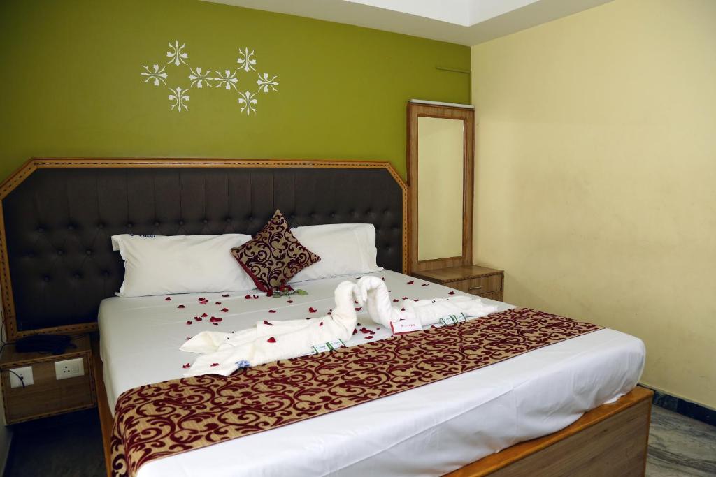 a bedroom with a bed with christmas decorations on it at Hotel Vijay in Pollāchi