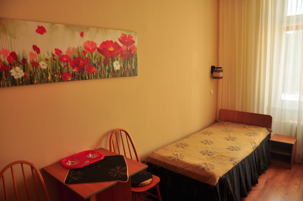 a room with a bed and a table and a painting at FWP Rybniczanka - Wanda in Lądek-Zdrój