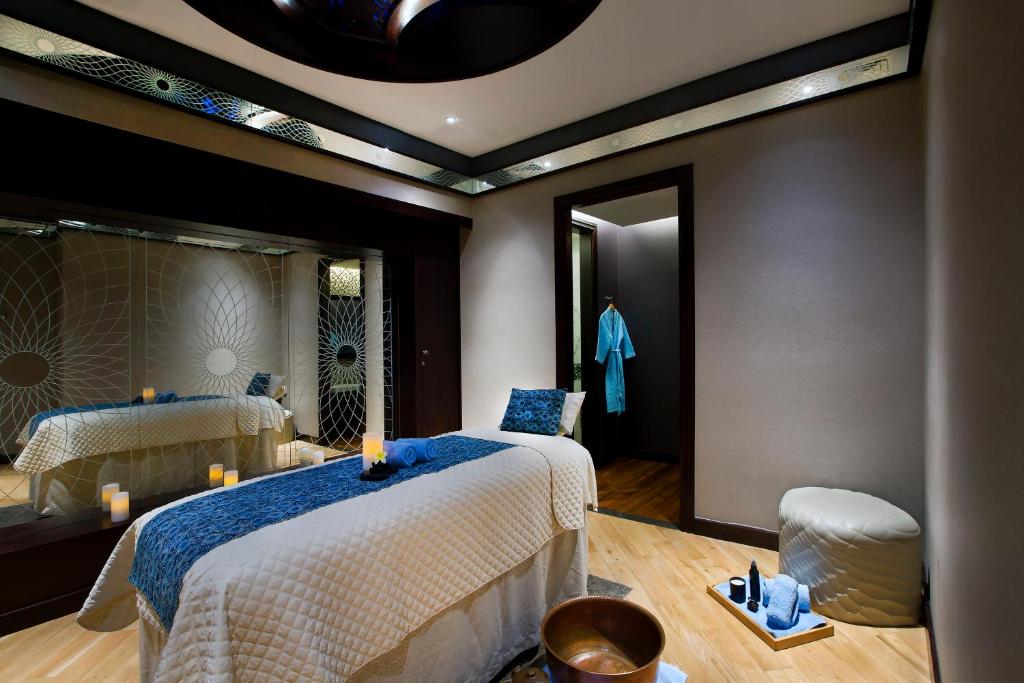 a bedroom with two beds and a mirror at Bab Al Qasr Residence in Abu Dhabi