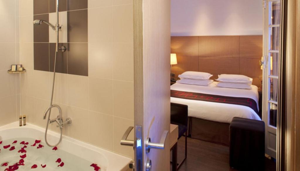 a hotel room with a bed and a bath tub at Villathena in Paris