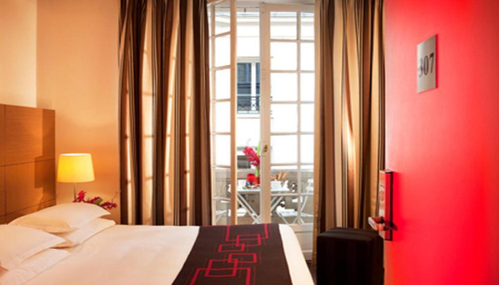 a bedroom with a bed and a red wall at Villathena in Paris
