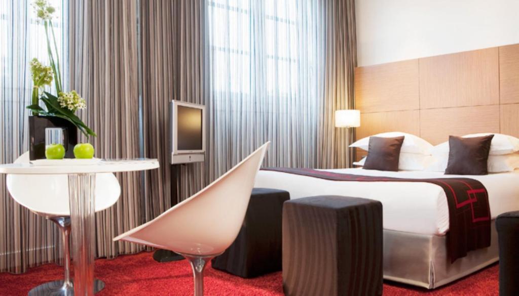 a hotel room with a bed and a table at Villathena in Paris