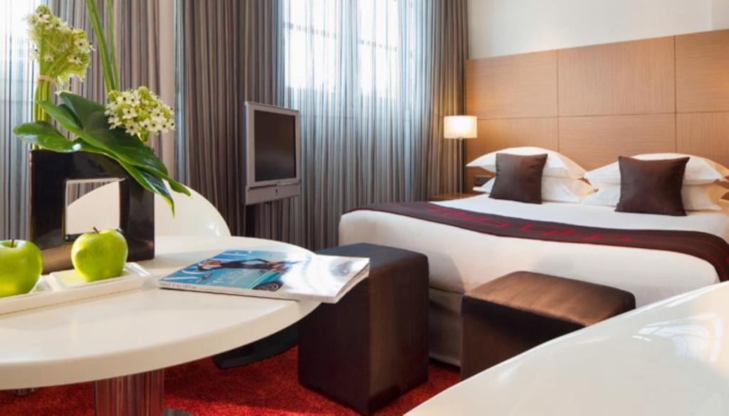 a hotel room with two beds and a table at Villathena in Paris