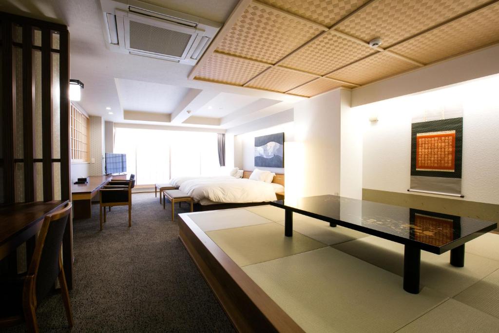 a room with a bed and a table in a room at Kyoto Kamanza Hotel in Kyoto