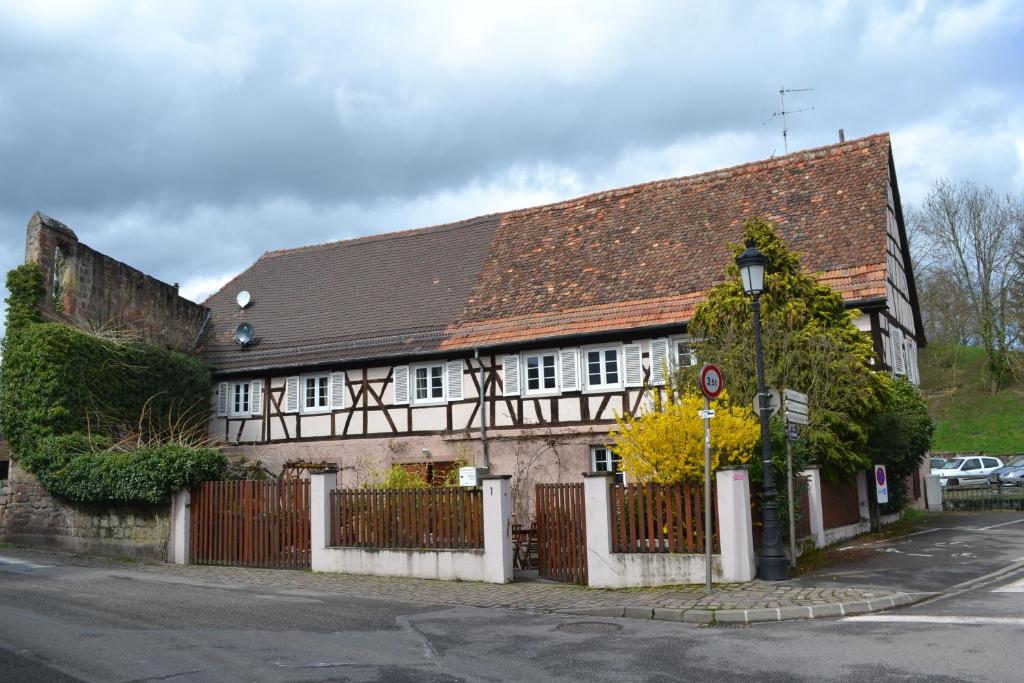 une maison blanche et noire avec une clôture dans l'établissement Ferienhaus Pfistermühle, à Wissembourg