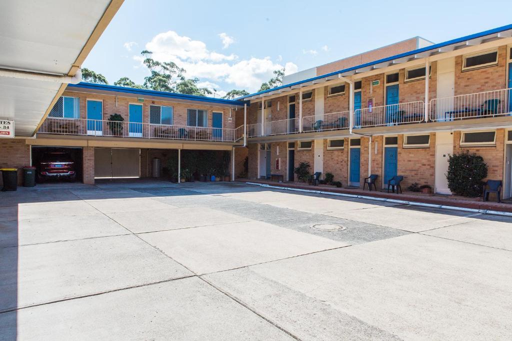 un aparcamiento vacío frente a un edificio en Bentleigh Motor Inn en Coffs Harbour