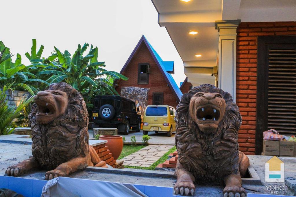 Una statua di due leoni seduti sopra un tavolo di D Family Resort a Anuradhapura