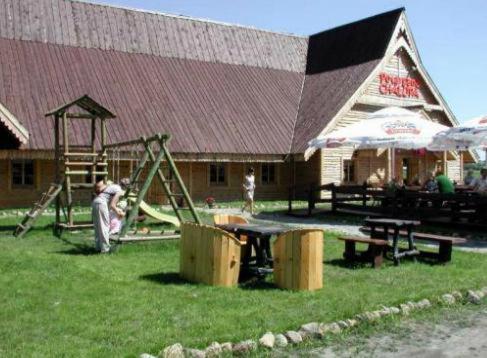 a playground in front of a building with a slide at Potargana Chałupa in Lubień Kujawski