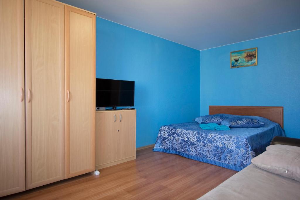 a blue bedroom with a bed and a television at ApartLux Sokolnicheskaya Superior in Moscow