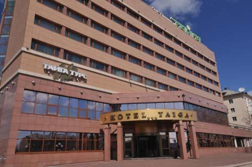 ブラーツクにあるHotel Taigaの目の前に看板が立つホテルの建物